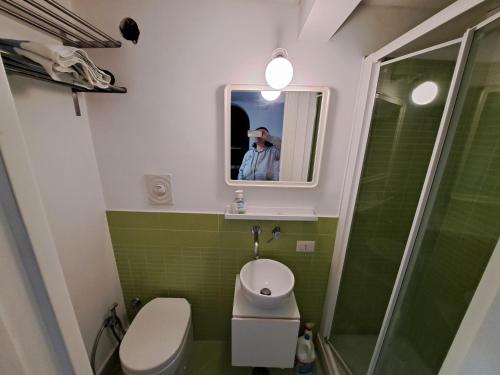 a man taking a picture of a bathroom with a toilet and a shower at Carmela Camera&Comfort Monolocale in Caserta