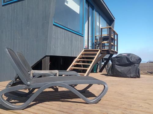 una silla sentada en una terraza junto a un edificio en Cabaña con jacuzzi campo mar en Matanzas