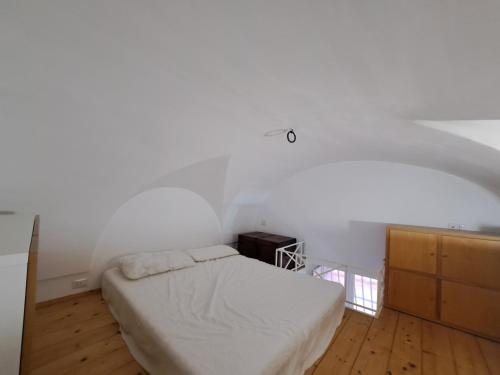 a bedroom with a bed and a white wall at Carmela Camera&Comfort Monolocale in Caserta