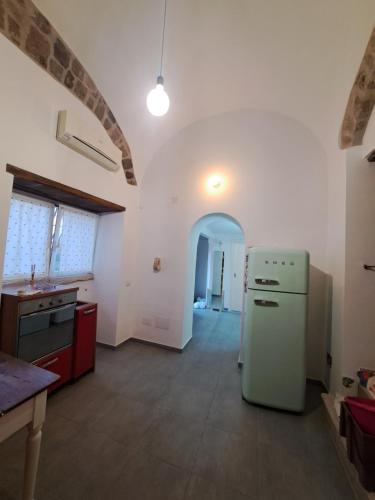 cocina con nevera blanca en una habitación en Carmela Camera&Comfort Monolocale, en Caserta