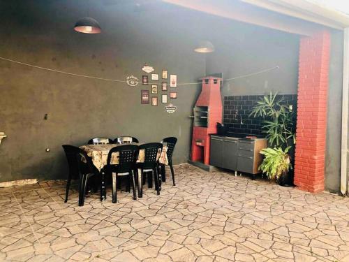 a dining room with a table and black chairs at Bertioga Casa pertinho da Praia in Bertioga