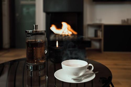 a cup of coffee sitting on a table with a candle at VÜ Terrassen-Chalets in Münchberg