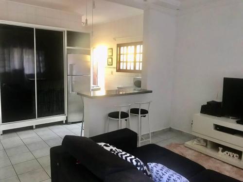 a living room with a couch and a kitchen at Bertioga Casa pertinho da Praia in Bertioga