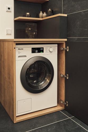 a washing machine in a cabinet in a kitchen at VÜ Terrassen-Chalets in Münchberg