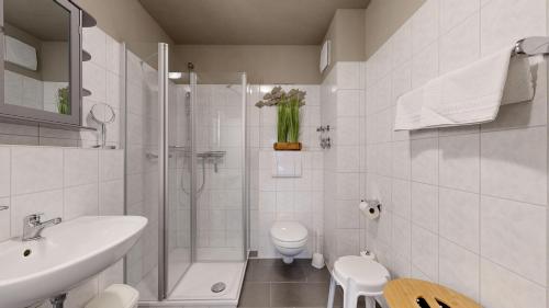 a white bathroom with a shower and a toilet at Apartmenthaus Binzer Sterne in Binz