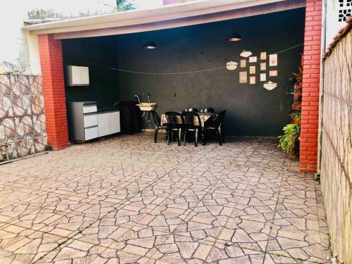 a patio with a table and chairs in a garage at Bertioga Casa pertinho da Praia in Bertioga