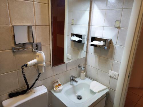 a bathroom with a sink and a mirror and a phone at Residence San Miguel (centro storico) in Vicenza