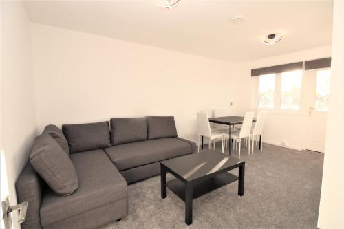 a living room with a couch and a table at Lovely Flat Near Lewisham in Hither Green