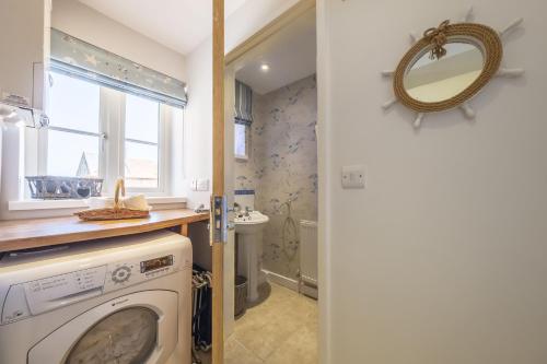 a washing machine in a bathroom with a mirror at Seaview Cottage in Hunstanton