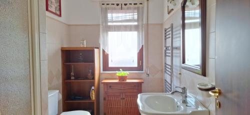 a bathroom with a sink and a toilet and a window at Panoramica Casa Leo Riposto centro con parcheggio in Riposto