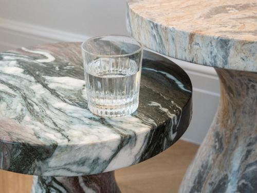 a glass of water sitting on a marble table at The Dolli at Acropolis, A Hotel to Live in Athens