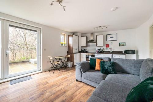 a living room with a couch and a kitchen at Stunning 1 BD flat in Lochend Park with a patio in Edinburgh