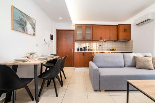 een woonkamer en een keuken met een bank en een tafel bij Kyma 4 - 5 min to Beach in Kos-stad
