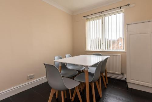 a dining room with a white table and chairs at 3 Bed Apartment - Perfect for Contractors near Liverpool Airport in Hale