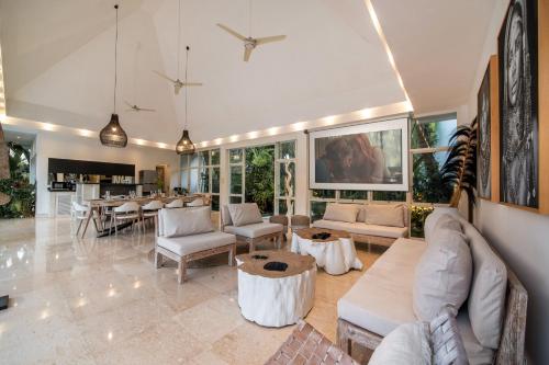 uma grande sala de estar com sofás e uma mesa em Jacques 5 Villas Complex Ubud em Ubud