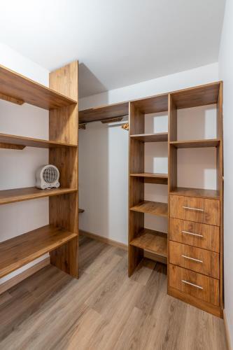 a walk in closet with wooden shelves at Penthouse Chicalá Colombian Experience in Parque Virrey in Bogotá
