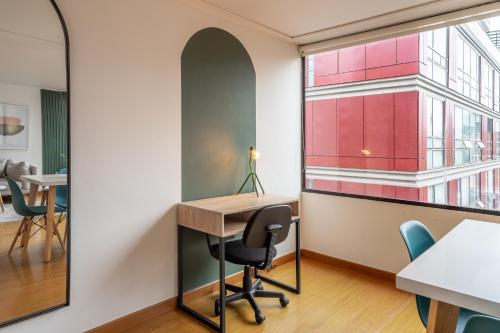 an office with a desk and chairs and a window at Penthouse Chicalá Colombian Experience in Parque Virrey in Bogotá