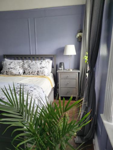 a bedroom with a bed and a nightstand and a plant at Brooklyn Flat Tropical Vibe in Brooklyn