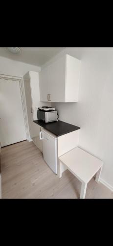een witte keuken met een aanrecht en een magnetron bij Capital city of Lego, Prime location! Room 01 in Billund