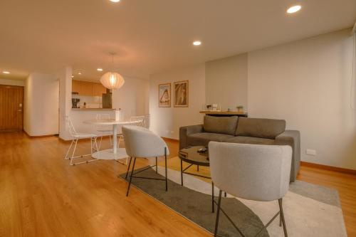 a living room with a couch and a table and chairs at Penthouse Chicalá Colombian Experience in Parque Virrey in Bogotá