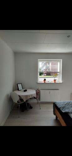 een witte kamer met een tafel en een raam bij Capital city of Lego, Prime location! Room 01 in Billund