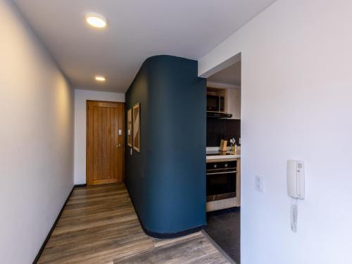 a hallway with a blue wall in a kitchen at Penthouse Chicalá Colombian Experience in Parque Virrey in Bogotá