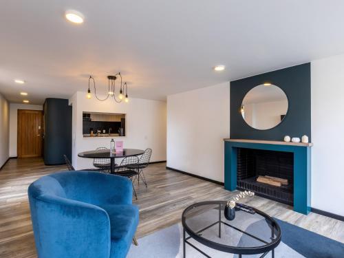 a living room with a blue chair and a fireplace at Penthouse Chicalá Colombian Experience in Parque Virrey in Bogotá