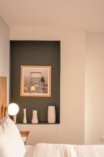 a bedroom with a black wall with three white vases at Penthouse Chicalá Colombian Experience in Parque Virrey in Bogotá