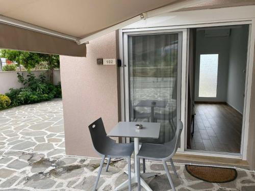 un patio con 2 sedie e un tavolo sul balcone di Coral Boutique Apartments a Ofrínion