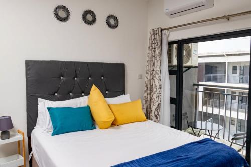 ハボローネにあるAlpha303のベッドルーム1室(黄色と青の枕付きのベッド1台付)