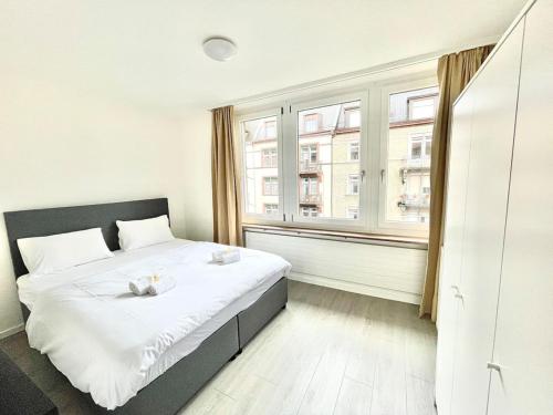 ein Schlafzimmer mit einem Bett und einem großen Fenster in der Unterkunft Urban Oasis with Queen Bed and View BE-18 in Zürich