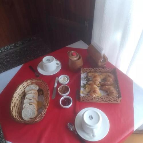 una mesa con un mantel rojo con comida. en Lomita Gesell, en Villa Gesell