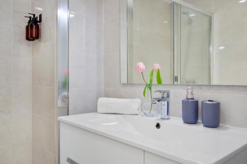a white bathroom with a sink and a mirror at Ocean House 1713 By IVI Real Estate in Torremolinos