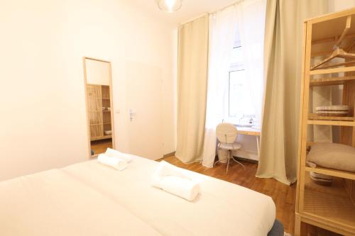 a white bedroom with a bed and a window at Ruby holiday home with patio in Vienna