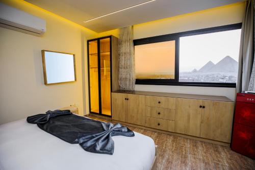 a bedroom with a bed and a large window at Piccolo Mondo Boutique Hotel in Cairo