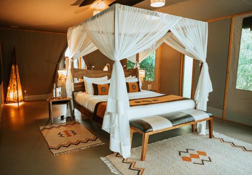 a bedroom with a bed with a canopy at Soroi Luxury Migration Camp in Sekenani