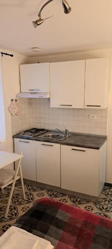 kuchnia z białymi szafkami i piekarnikiem w obiekcie Studio Bandiera apartment w mieście Palermo