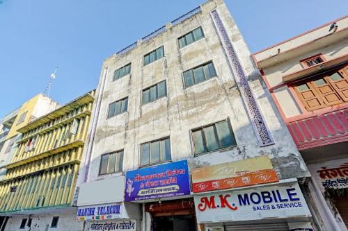 an old building on a city street with signs at OYO Hotel Neelkamal palace and Guest house in Nāthdwāra