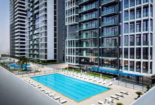 an overhead view of a swimming pool in front of tall buildings at HAVN - 2 Bedroom Apartment in Bloom Tower, JVC in Dubai