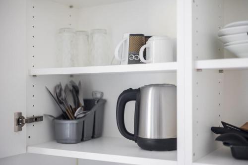 a kitchen shelf with a coffee pot and utensils at Urban Oasis with Queen Bed and View BE-19 in Zürich