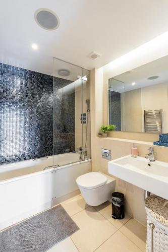 a bathroom with a toilet and a sink and a shower at King beds apartment with en-suite, private balcony and elevator by iconic Portobello Market in London