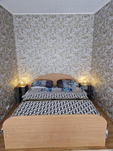a bedroom with a large bed in a room with wallpaper at Karolina in Daugavpils