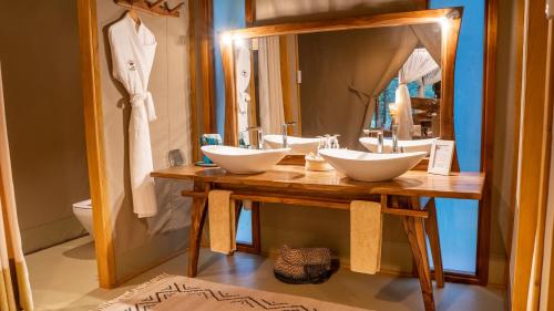 a bathroom with two sinks and a mirror at Soroi Luxury Migration Camp in Sekenani