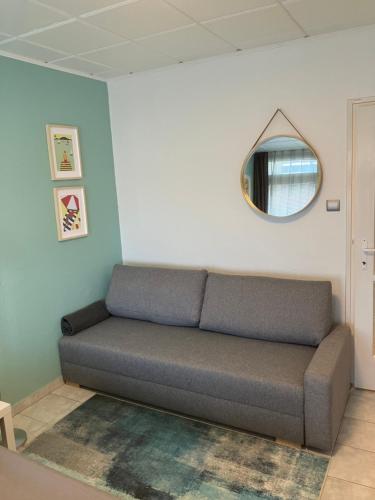 a couch sitting in a room with a mirror at Hátszél Apartman in Balatonfüred