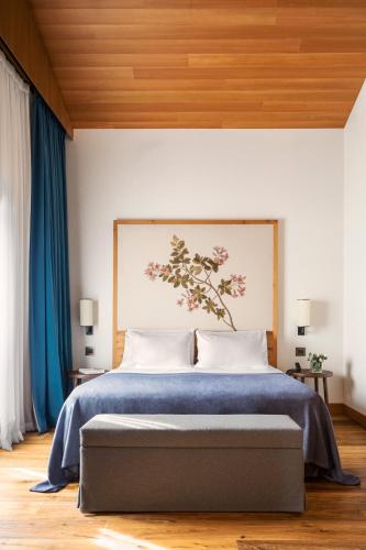 a bedroom with a large bed with a blue blanket at Faloria Mountain Spa Resort in Cortina dʼAmpezzo