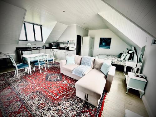 ein Wohnzimmer mit einem Sofa und einer Küche in der Unterkunft Stoneridge farm in Plettenberg Bay
