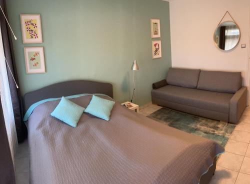 a bedroom with a bed and a couch at Hátszél Apartman in Balatonfüred