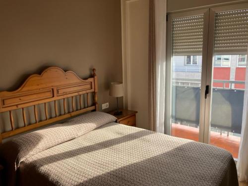 a bedroom with a bed and a window with a view at Vivienda estación in Ourense