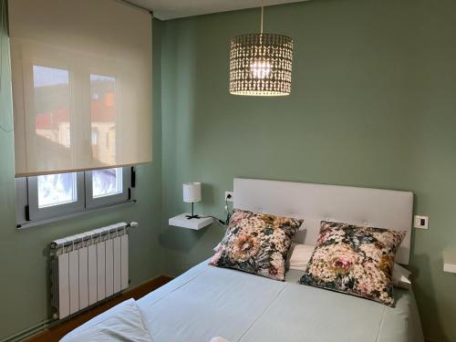 a bedroom with a white bed with two pillows at Vivienda estación in Ourense