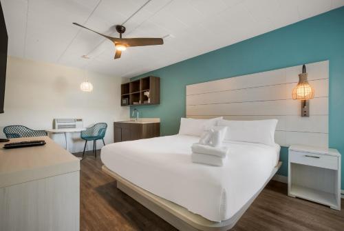 a bedroom with a large white bed and a desk at Hotel Cabana Oceanfront/Boardwalk in Wildwood
